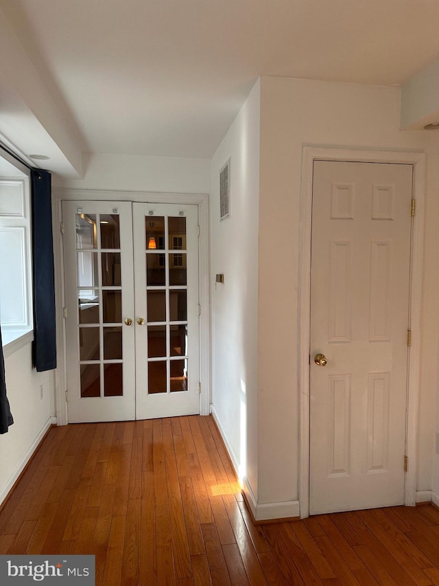 corridor featuring hardwood / wood-style floors and french doors