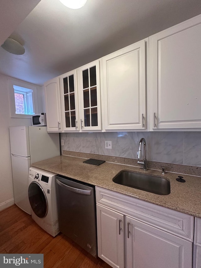 kitchen with sink, dishwasher, white cabinets, dark hardwood / wood-style flooring, and washer / clothes dryer