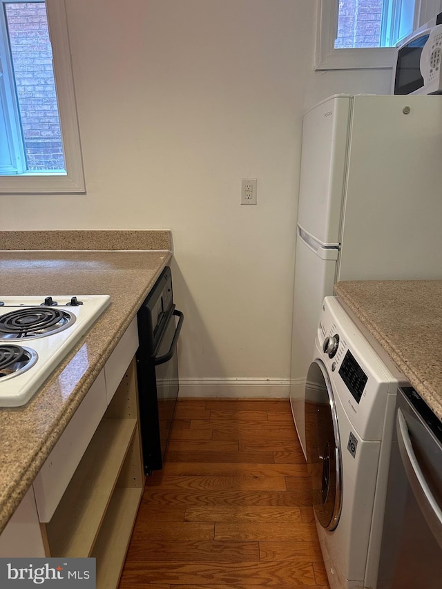 kitchen featuring dark hardwood / wood-style flooring, washer / clothes dryer, white appliances, and white cabinets