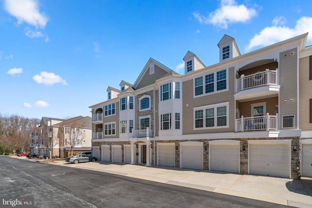 view of property featuring a residential view, a garage, and driveway