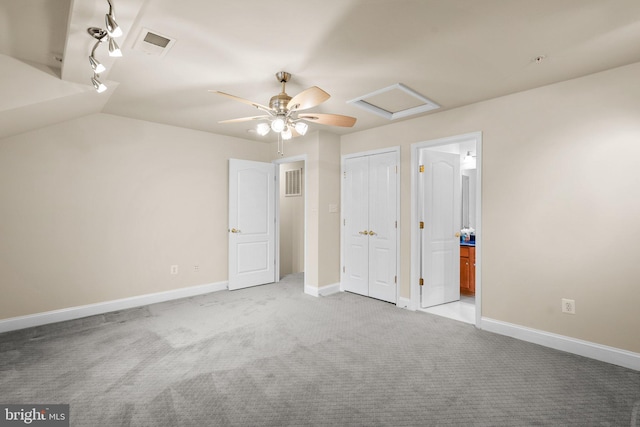 unfurnished bedroom with ensuite bath, vaulted ceiling, light colored carpet, and ceiling fan