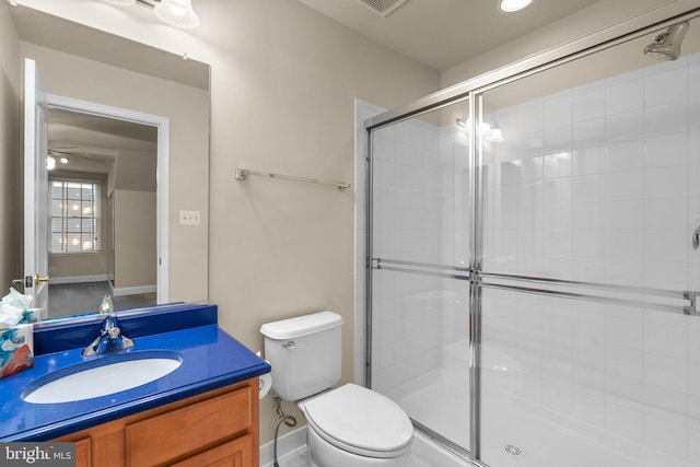 bathroom with a shower with door, vanity, and toilet