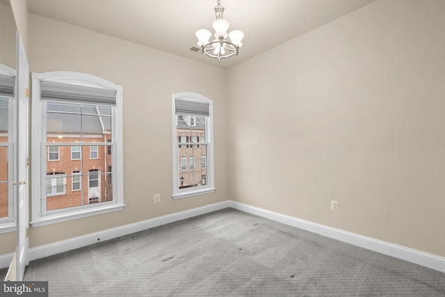 unfurnished room with an inviting chandelier and carpet floors