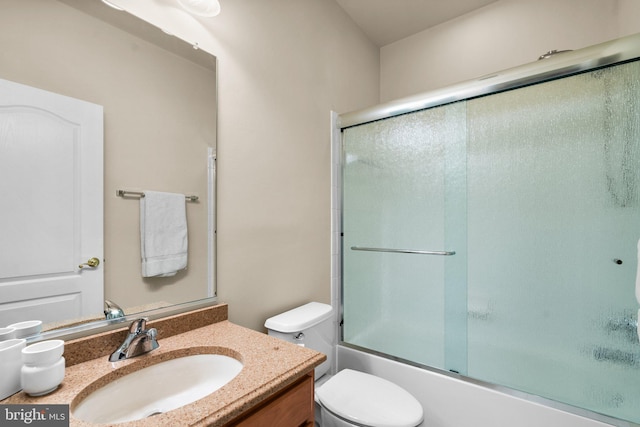 full bathroom featuring vanity, bath / shower combo with glass door, and toilet