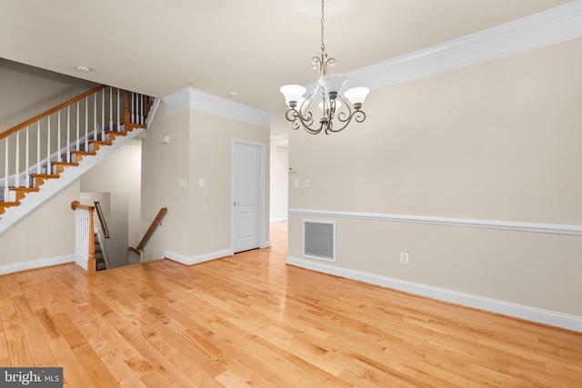 interior space with wood-type flooring, a chandelier, and crown molding