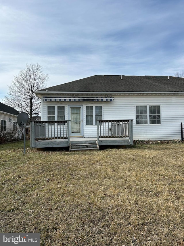 back of house featuring a deck and a lawn