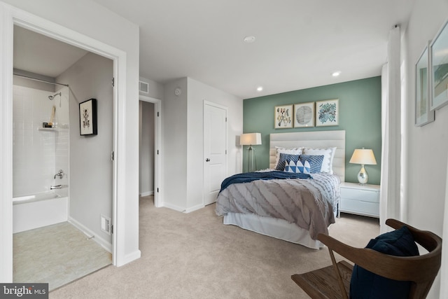 bedroom featuring ensuite bathroom, recessed lighting, light colored carpet, visible vents, and baseboards