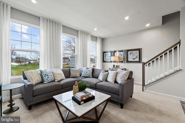 living room featuring recessed lighting, light carpet, baseboards, and stairs