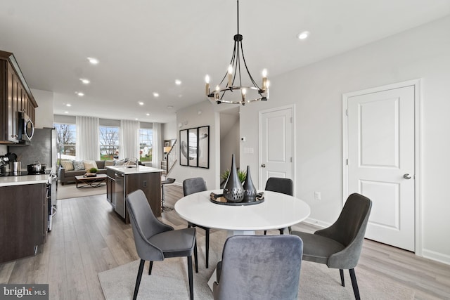 dining room with light wood finished floors, baseboards, and recessed lighting