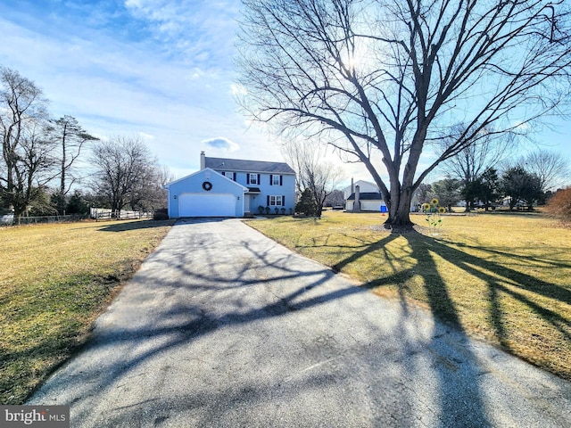 view of front of property featuring a garage and a front lawn