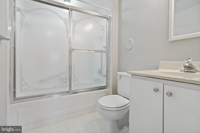 full bathroom with vanity, bath / shower combo with glass door, tile patterned floors, and toilet