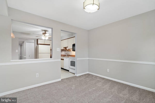 unfurnished living room featuring ceiling fan, light colored carpet, and sink