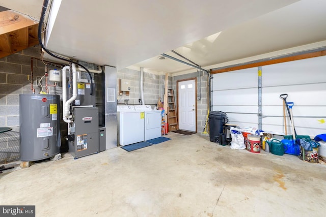 garage featuring water heater, heating unit, and separate washer and dryer