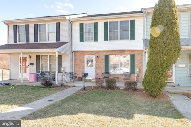 view of property featuring covered porch and a front lawn