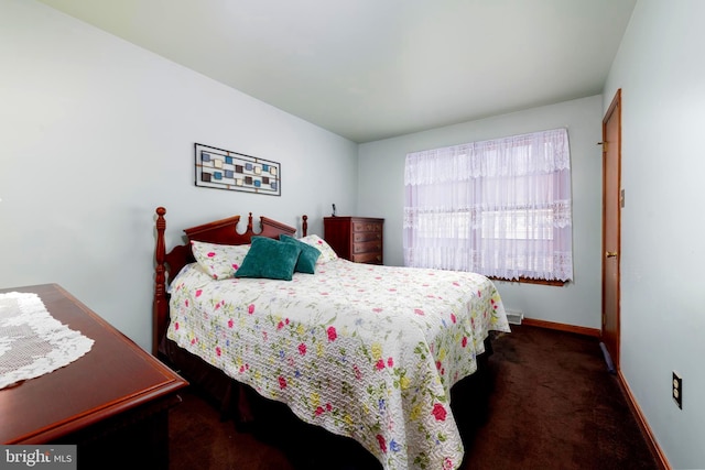 bedroom with dark colored carpet