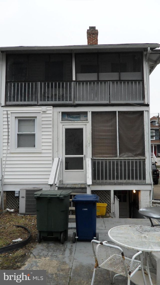 back of house with cooling unit, a patio area, and a balcony