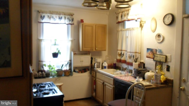 kitchen with sink, light brown cabinets, black range with gas stovetop, and a chandelier