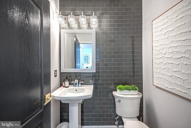 bathroom with tile walls, sink, decorative backsplash, and toilet