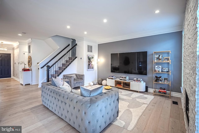 living room featuring crown molding and light hardwood / wood-style floors