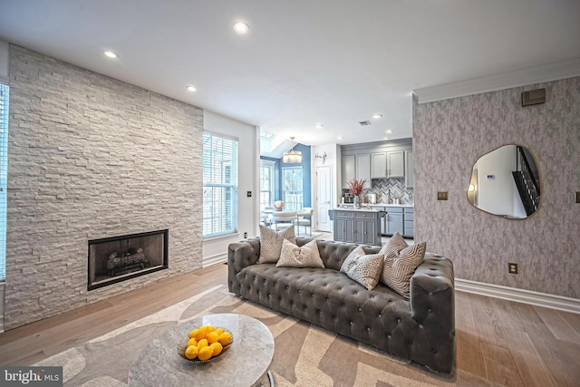 living room with a stone fireplace and light hardwood / wood-style floors