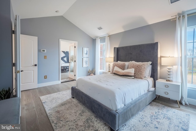 bedroom featuring lofted ceiling and light hardwood / wood-style flooring