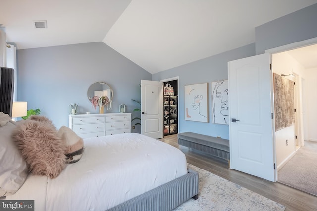 bedroom with light hardwood / wood-style floors and vaulted ceiling