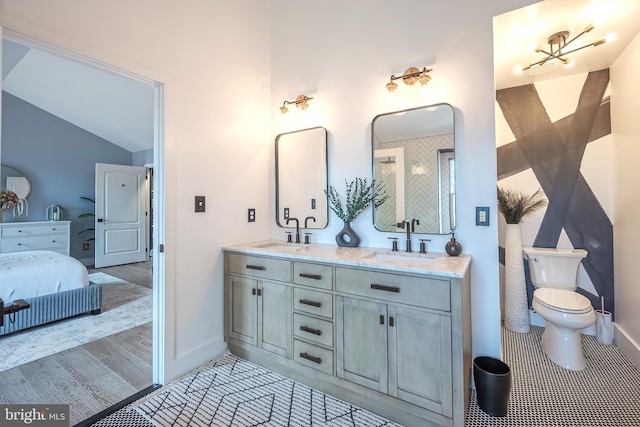 bathroom with tile patterned floors, vanity, toilet, and vaulted ceiling