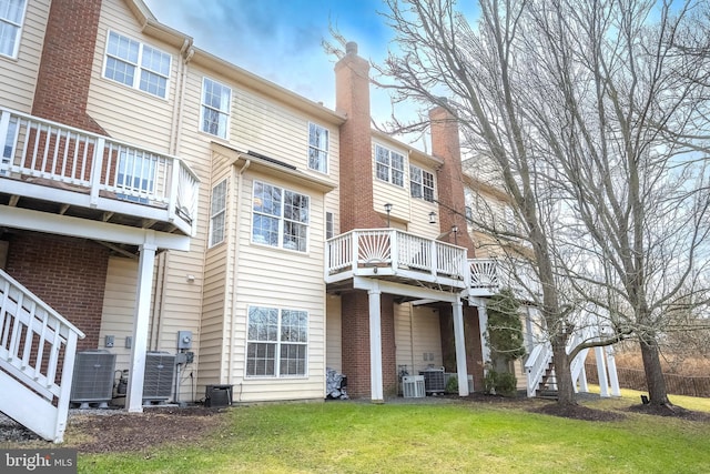 back of house featuring central AC and a lawn