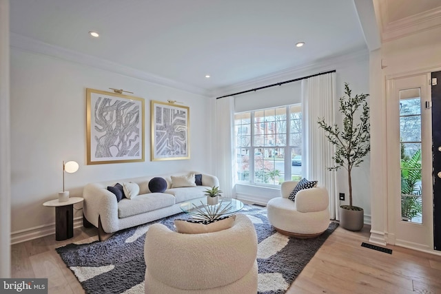 living room featuring ornamental molding and light hardwood / wood-style floors