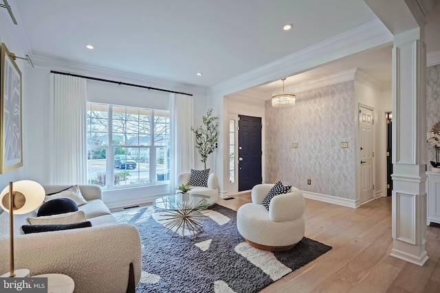 living room featuring crown molding, ornate columns, and light wood-type flooring