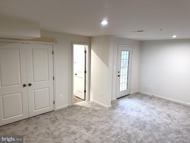 unfurnished room featuring light colored carpet, visible vents, and baseboards