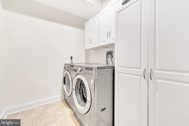 laundry room with light tile patterned flooring, cabinets, and washing machine and dryer