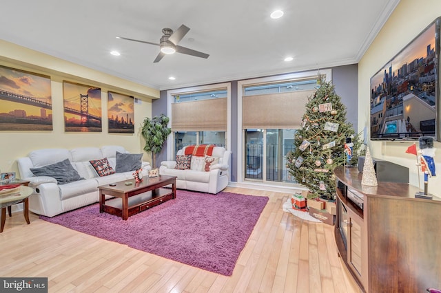 living room with ornamental molding, ceiling fan, and light hardwood / wood-style floors