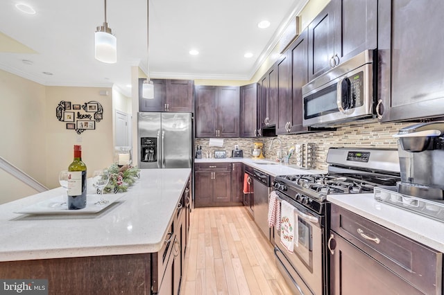 kitchen with pendant lighting, dark brown cabinetry, light stone counters, stainless steel appliances, and crown molding