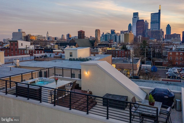 patio terrace at dusk featuring a balcony and grilling area