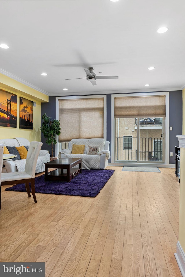 living room with ornamental molding, ceiling fan, and light hardwood / wood-style flooring