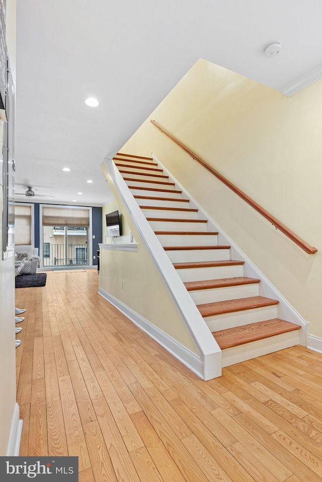 stairway featuring hardwood / wood-style flooring and ceiling fan