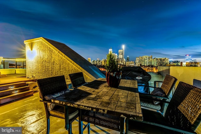 patio terrace at dusk featuring area for grilling