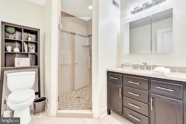 bathroom featuring vanity, tile patterned flooring, a shower with shower door, and toilet