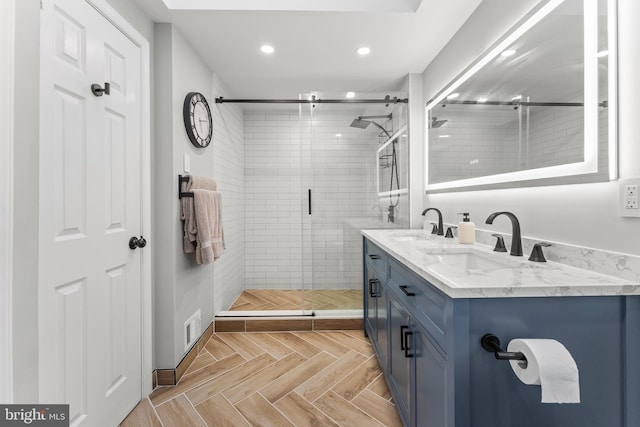 bathroom featuring a stall shower, visible vents, a sink, and double vanity