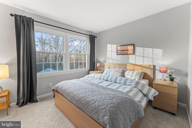 carpeted bedroom with lofted ceiling and baseboards