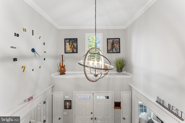 foyer entrance with an inviting chandelier, a high ceiling, and crown molding