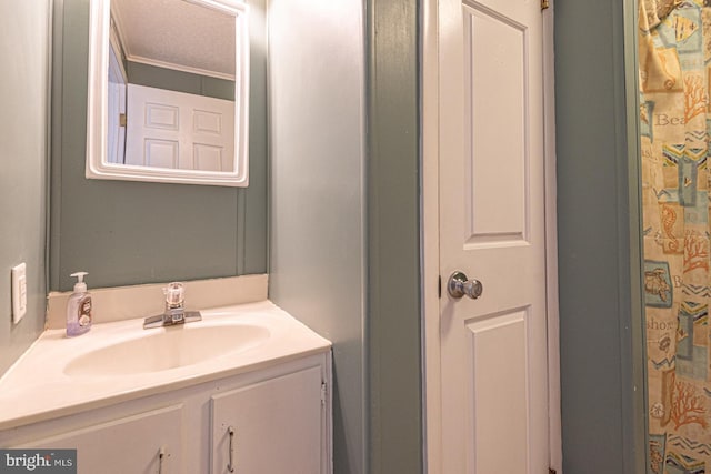 bathroom with ornamental molding, vanity, and a textured ceiling