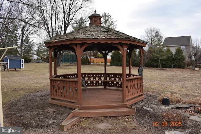 view of community with a gazebo, a storage unit, and a lawn