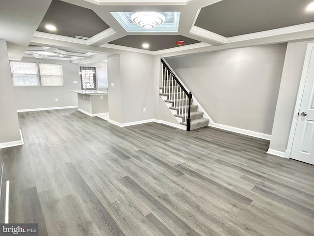 unfurnished living room featuring hardwood / wood-style flooring, coffered ceiling, and crown molding