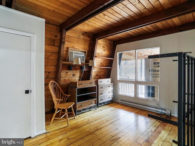 living area with wood walls, wooden ceiling, light wood-style floors, beam ceiling, and a baseboard heating unit