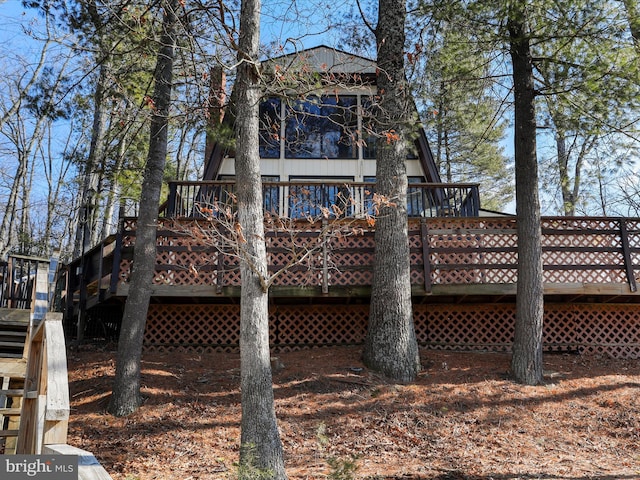 back of property featuring stairs and a wooden deck