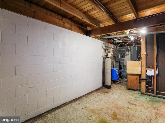 unfinished below grade area featuring electric panel and tile patterned floors