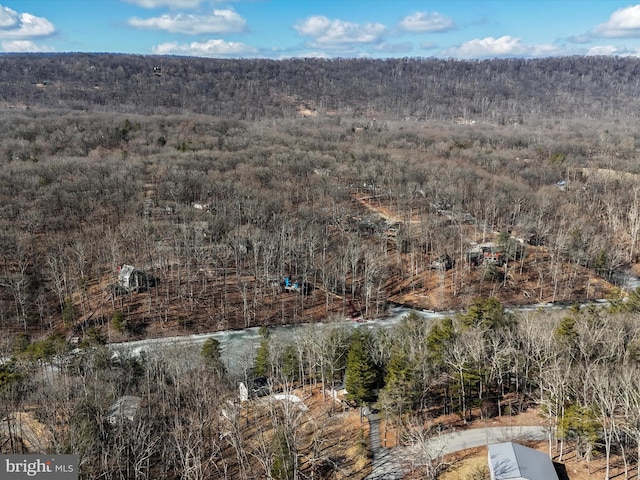 drone / aerial view featuring a wooded view