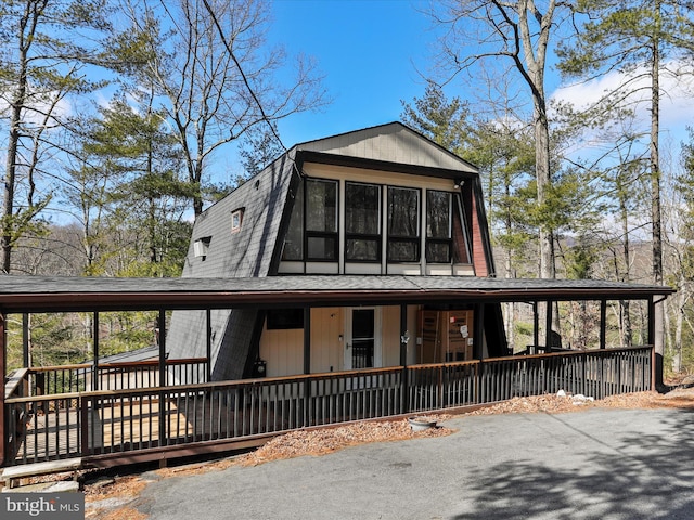 a-frame style home featuring a gambrel roof and a shingled roof